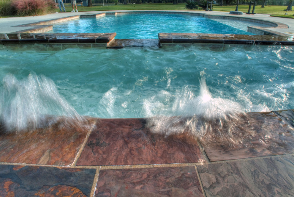 Example of a large backyard stone and custom-shaped natural hot tub design