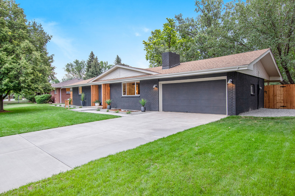 Mid-sized midcentury two-storey brick black house exterior in Denver with a gable roof and a shingle roof.