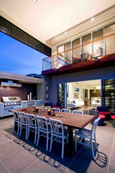 This is an example of a large contemporary backyard patio in Brisbane with natural stone pavers and a roof extension.