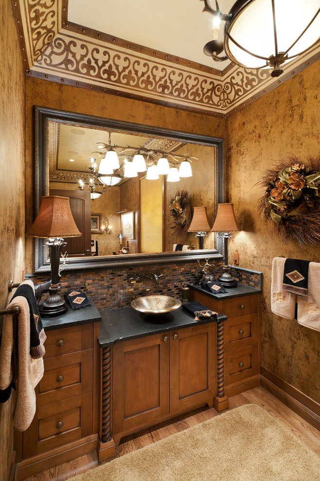 Photo of a traditional powder room in Other with a vessel sink and black benchtops.