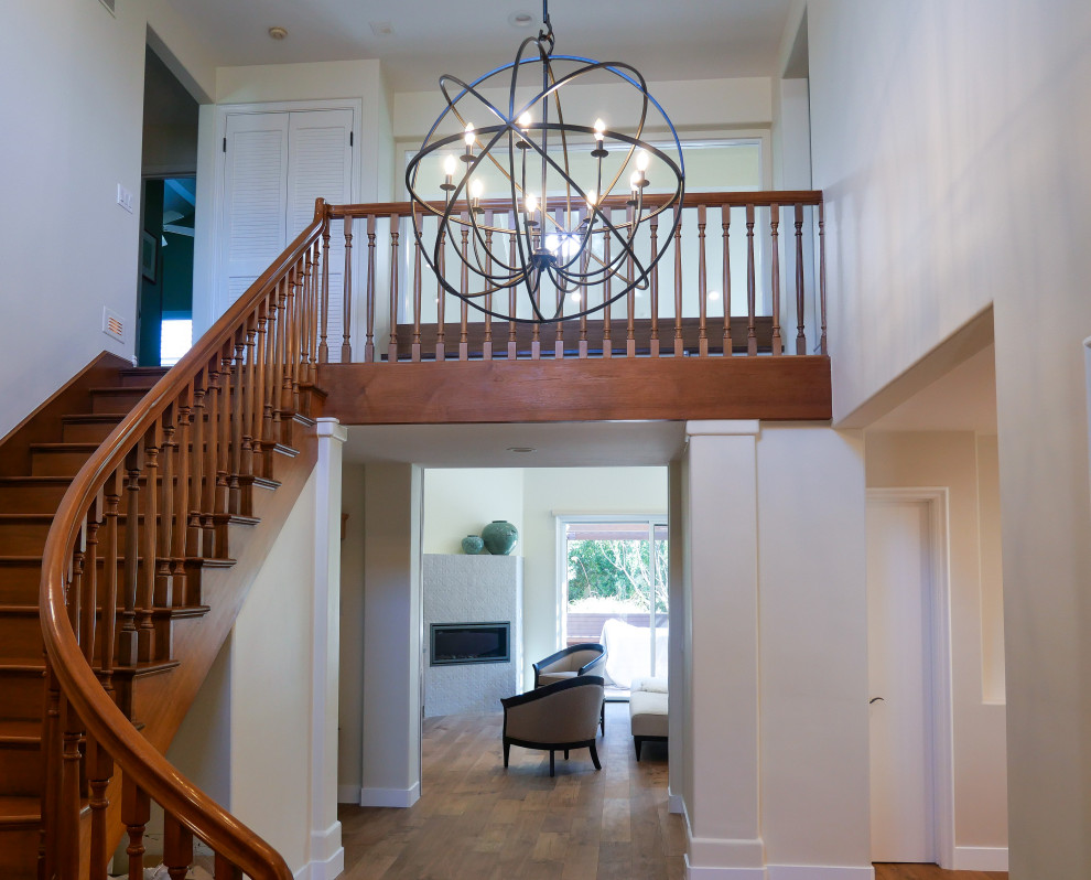 Medium sized traditional foyer in Los Angeles with beige walls, medium hardwood flooring, a single front door, a brown front door, brown floors and a vaulted ceiling.