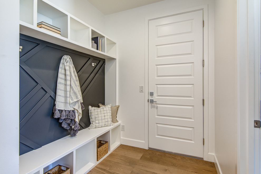 Mid-sized transitional medium tone wood floor and beige floor mudroom photo in Phoenix with white walls and a white front door