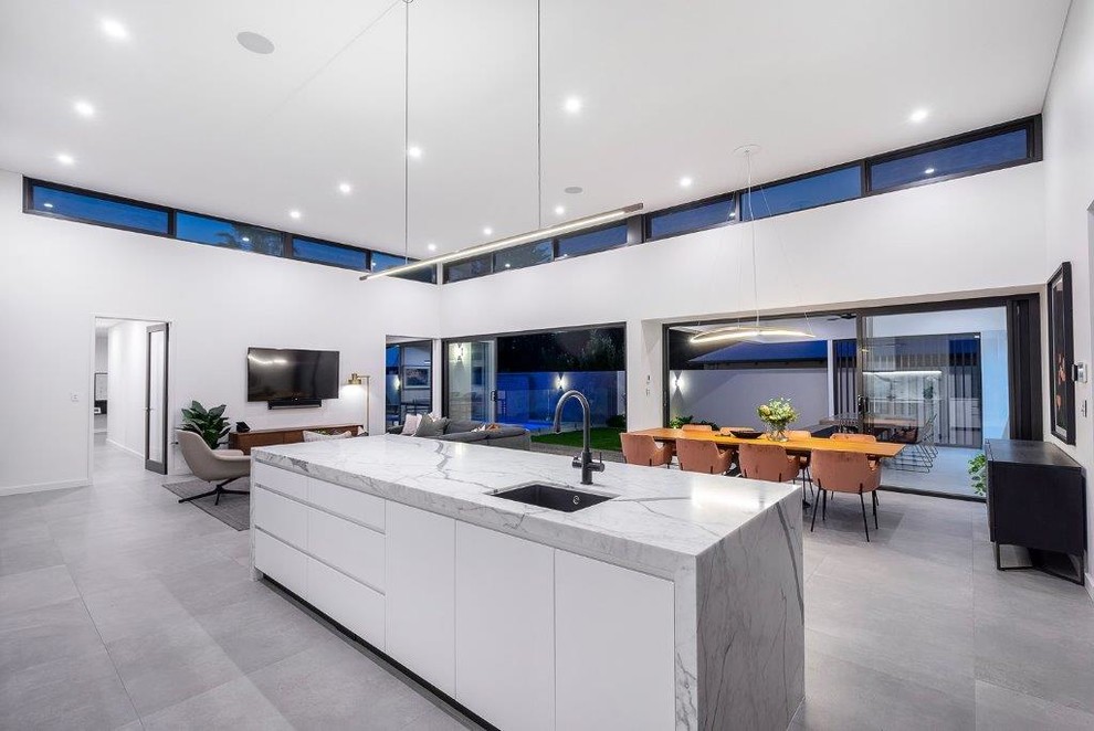 Photo of a large modern open plan kitchen in Perth with recessed-panel cabinets, white cabinets, with island, a single-bowl sink, marble benchtops, grey splashback, marble splashback, stainless steel appliances, ceramic floors, grey floor and grey benchtop.