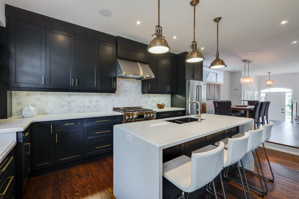 Inspiration for a mid-sized traditional l-shaped open plan kitchen in Toronto with a double-bowl sink, flat-panel cabinets, dark wood cabinets, solid surface benchtops, grey splashback, stainless steel appliances, dark hardwood floors and with island.