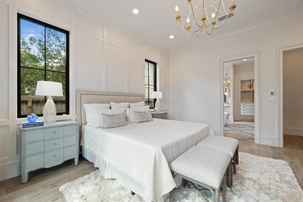 Geräumiges Klassisches Hauptschlafzimmer mit weißer Wandfarbe, braunem Holzboden, braunem Boden und Wandpaneelen in Houston