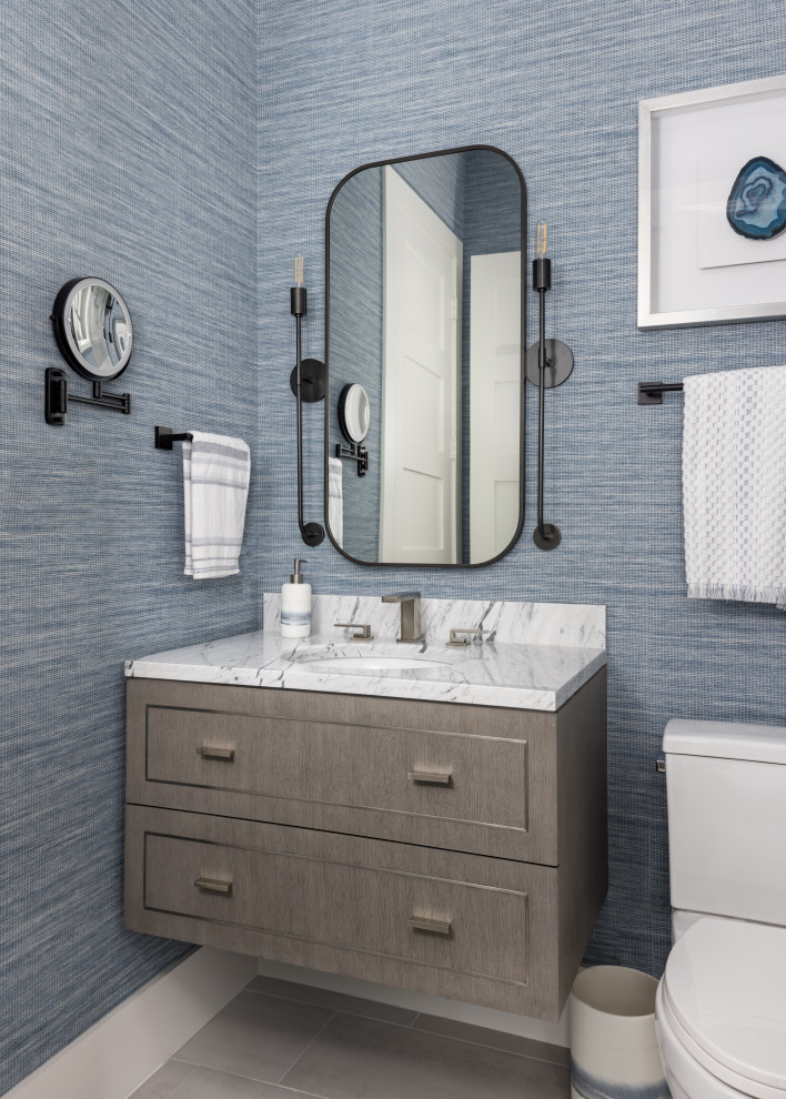 Esempio di una stanza da bagno tradizionale con ante in legno scuro, pareti blu, lavabo sottopiano, un lavabo e carta da parati