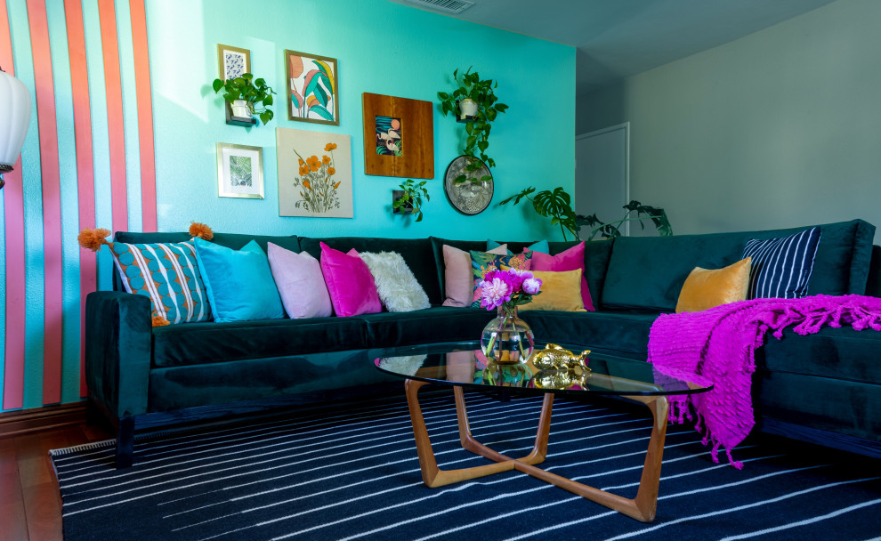 Esempio di un soggiorno tropicale di medie dimensioni e chiuso con pareti blu, pavimento in legno massello medio, TV a parete, pannellatura e pavimento rosso