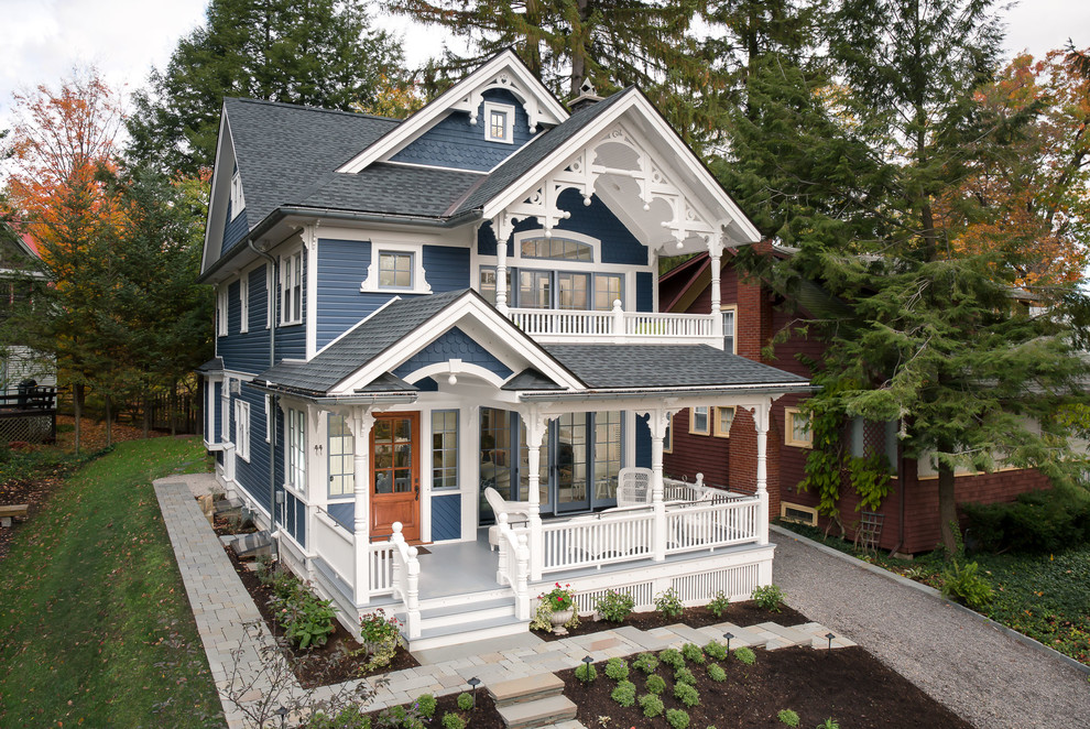 Traditional three-storey blue house exterior in Atlanta with a hip roof and a shingle roof.