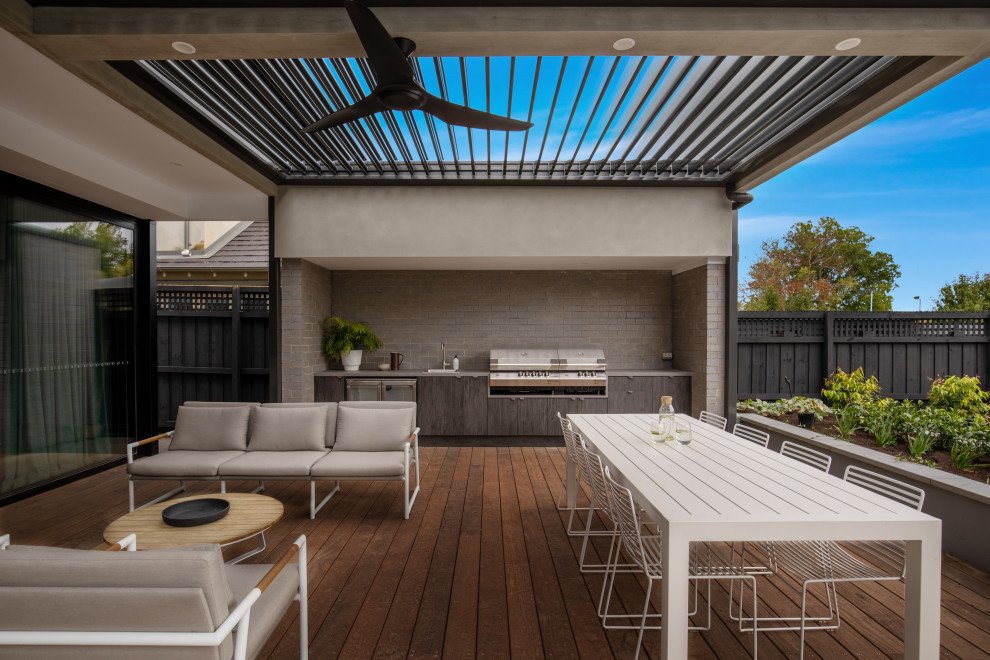 Inspiration for an expansive contemporary backyard and ground level deck in Melbourne with an outdoor kitchen and an awning.