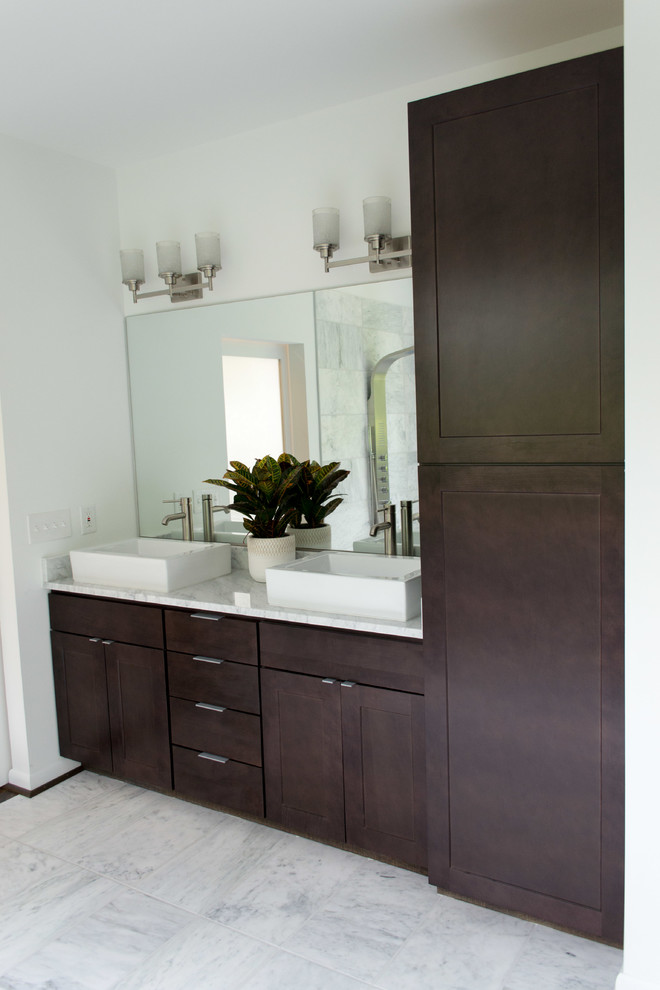 This is an example of a contemporary master bathroom in Raleigh with flat-panel cabinets, dark wood cabinets, an open shower, white tile, white walls, marble floors and marble benchtops.