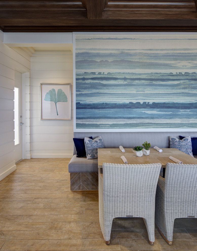 Expansive beach style dining room in Miami with white walls and light hardwood floors.