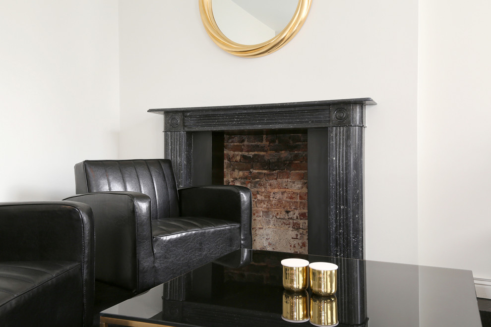 Photo of a small contemporary formal open concept living room in London with white walls, a standard fireplace, a stone fireplace surround and no tv.