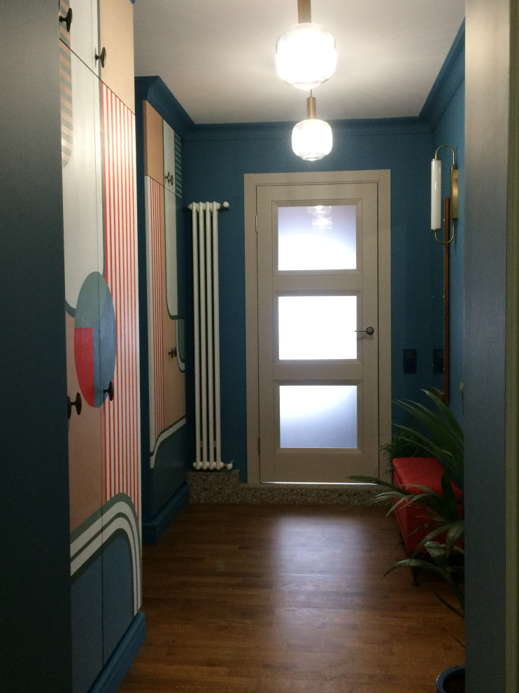 This is an example of an entry hall in Moscow with blue walls and medium hardwood floors.