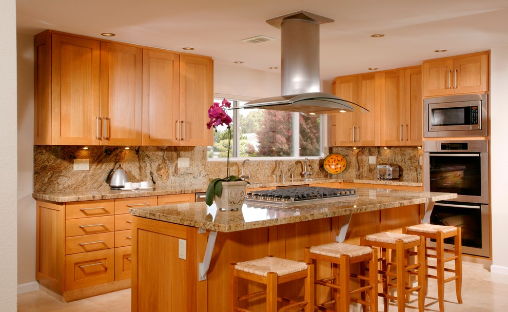 Photo of a large transitional l-shaped eat-in kitchen in San Diego with an undermount sink, shaker cabinets, medium wood cabinets, granite benchtops, beige splashback, stone slab splashback, stainless steel appliances, travertine floors, with island and beige floor.