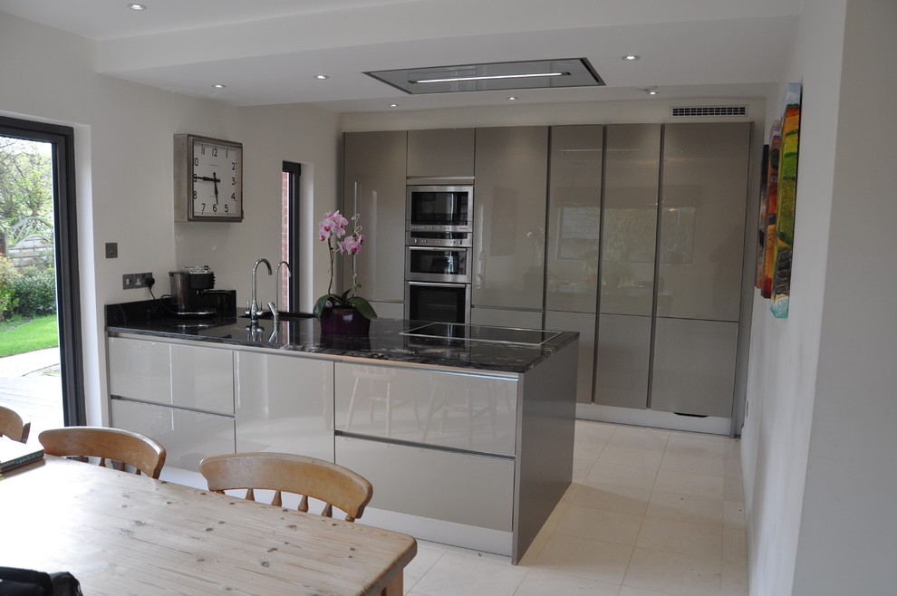 Mid-sized modern galley eat-in kitchen in Hertfordshire with an undermount sink, flat-panel cabinets, grey cabinets, granite benchtops, stainless steel appliances, ceramic floors and a peninsula.