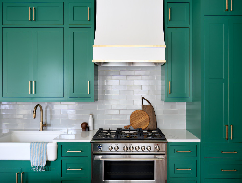 Mid-sized transitional galley medium tone wood floor and brown floor enclosed kitchen photo in Chicago with an undermount sink, recessed-panel cabinets, green cabinets, granite countertops, white backsplash, subway tile backsplash, stainless steel appliances, an island and white countertops