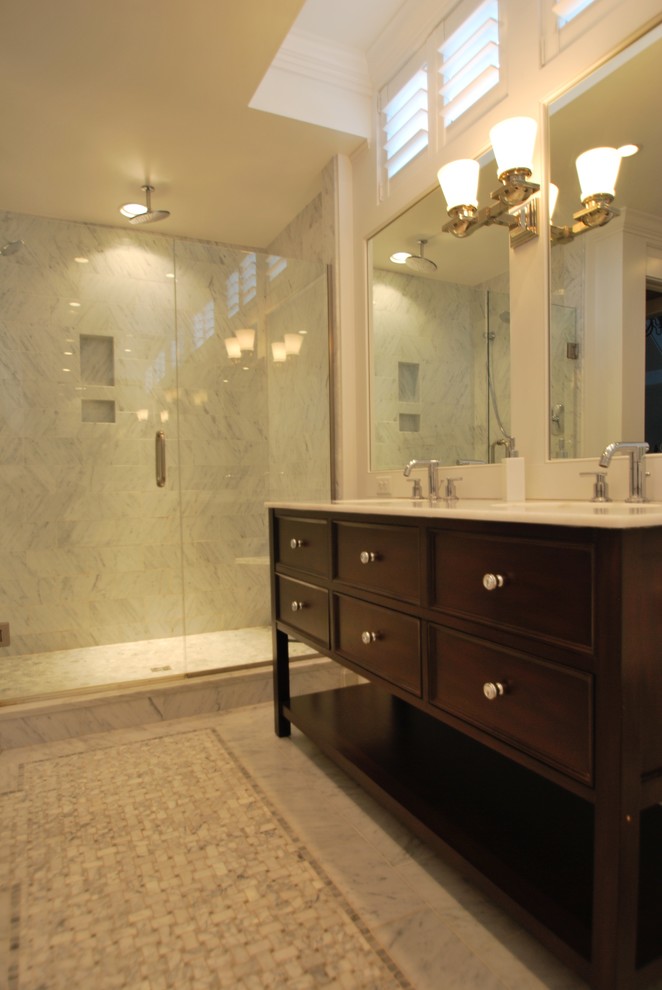 This is an example of a mid-sized transitional master bathroom in DC Metro with beaded inset cabinets, dark wood cabinets, an alcove shower, a two-piece toilet, gray tile, marble, white walls, marble floors, an undermount sink, marble benchtops, grey floor and a hinged shower door.