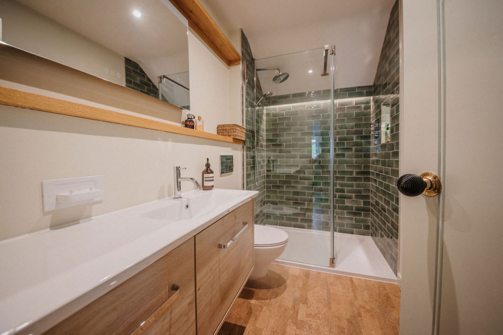 Minimalistisk inredning av ett mellanstort en-suite badrum, med släta luckor, en öppen dusch, en vägghängd toalettstol, grön kakel, porslinskakel, korkgolv, ett nedsänkt handfat och med dusch som är öppen