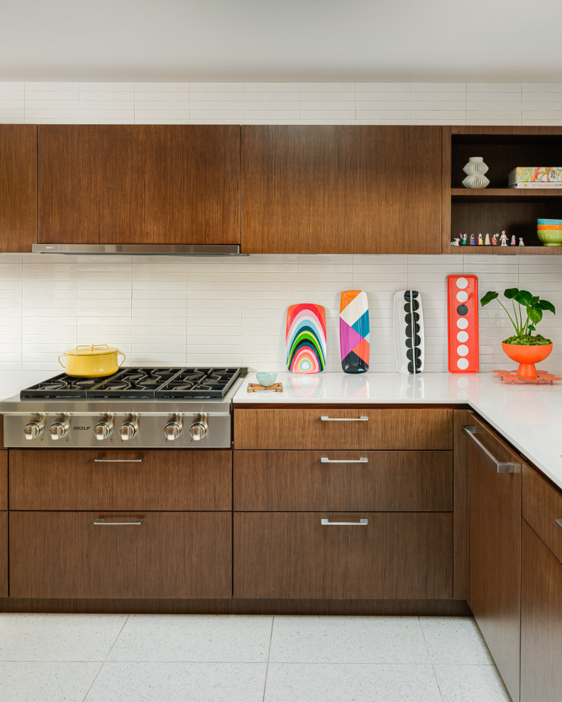 Design ideas for a medium sized midcentury u-shaped enclosed kitchen in San Francisco with flat-panel cabinets, dark wood cabinets, composite countertops, white splashback, stainless steel appliances, white floors, white worktops, a submerged sink, ceramic splashback and terrazzo flooring.