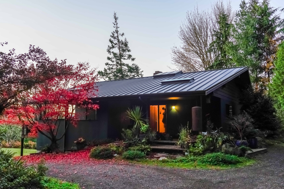 This is an example of a midcentury house exterior in Seattle with a metal roof.