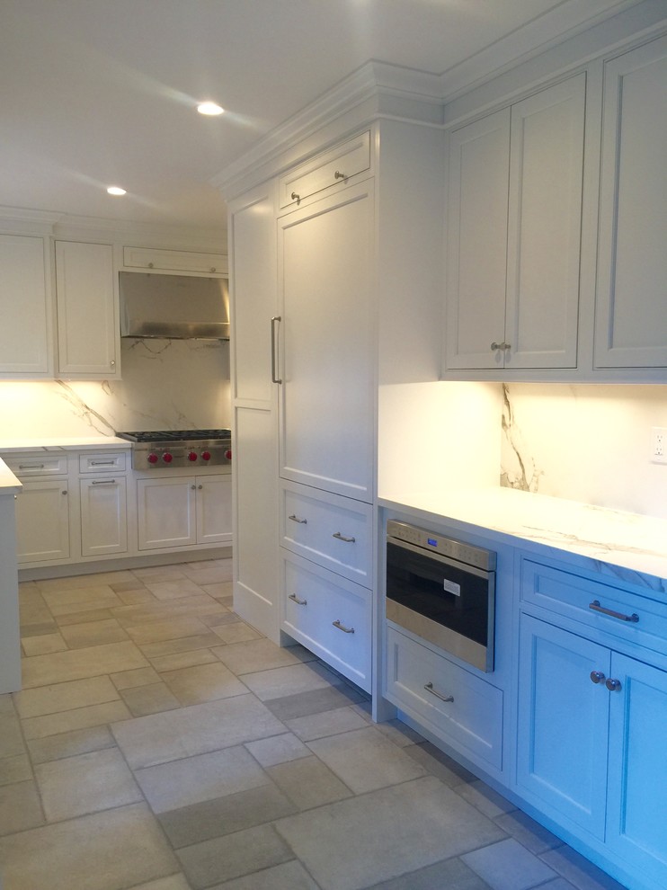 Mid-sized transitional l-shaped kitchen pantry in New York with an undermount sink, flat-panel cabinets, white cabinets, recycled glass benchtops, white splashback, glass sheet splashback, panelled appliances, dark hardwood floors and no island.