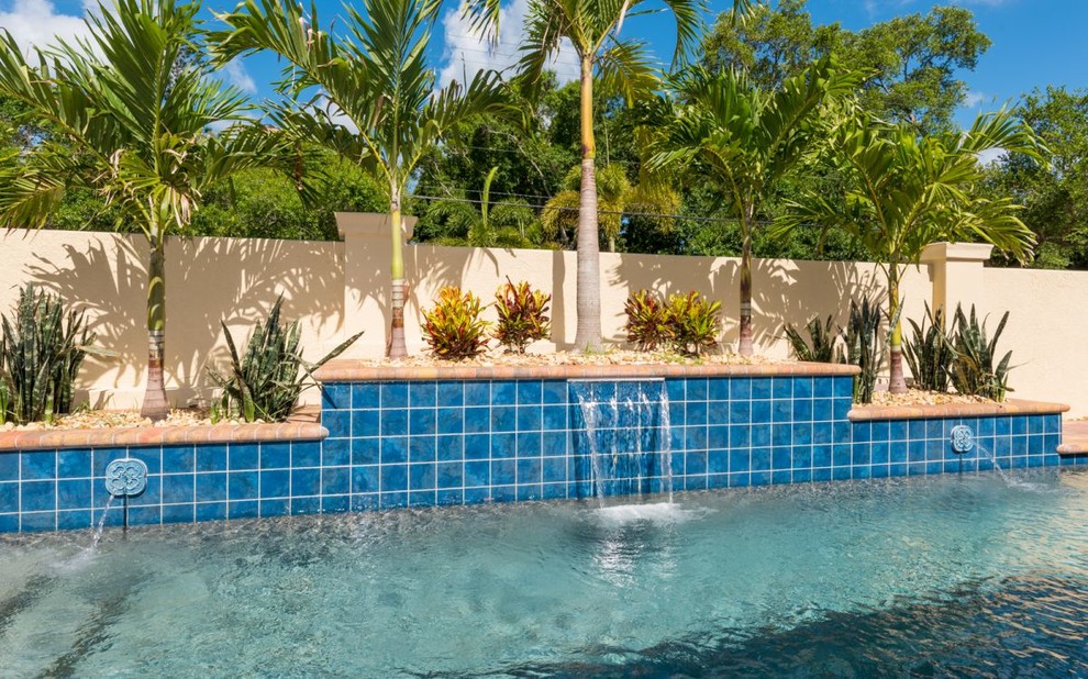 This is an example of a small traditional front yard rectangular lap pool in Tampa with a hot tub and concrete pavers.