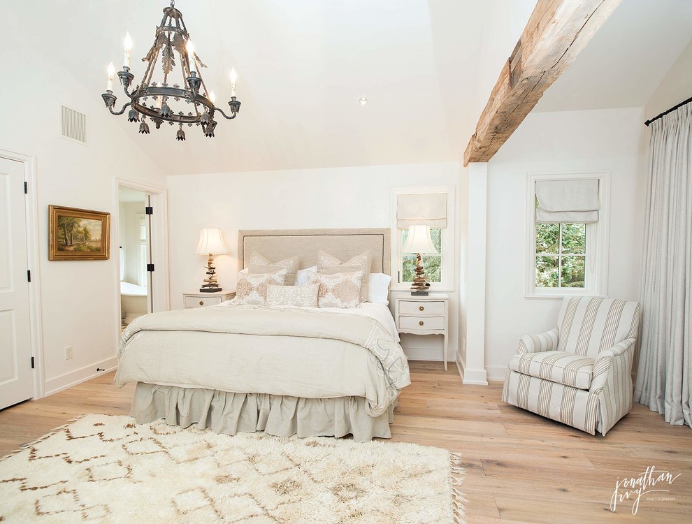 Photo of a large country master bedroom in Houston with white walls, light hardwood floors and no fireplace.
