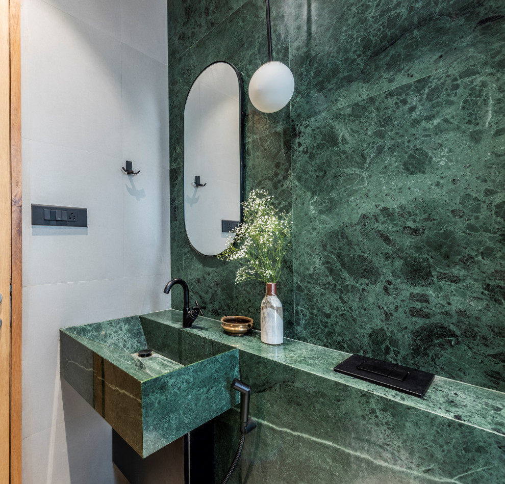 Cette photo montre une salle de bain tendance avec un carrelage vert, des dalles de pierre, une vasque, un plan de toilette vert et meuble simple vasque.