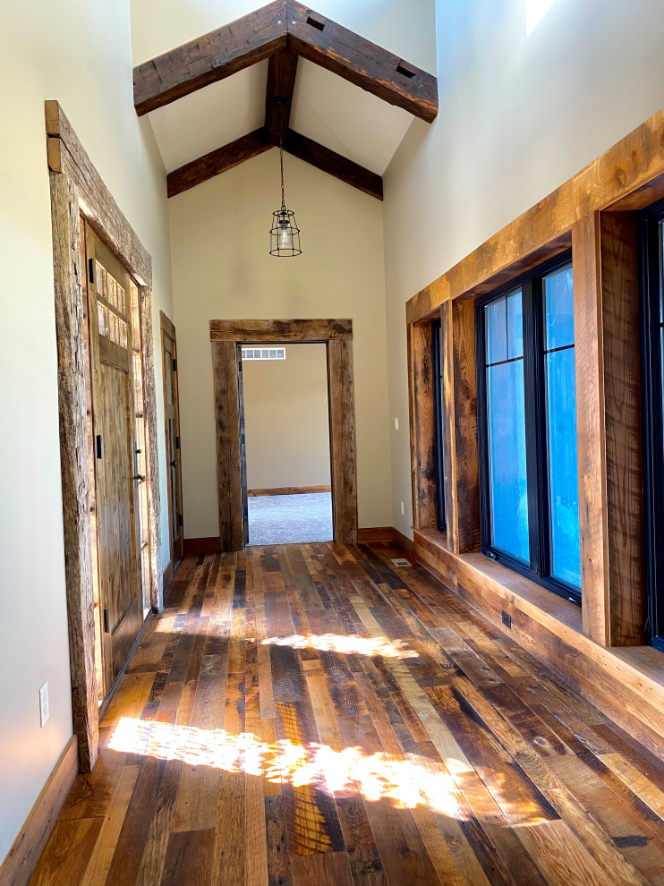 カンザスシティにあるお手頃価格の小さなラスティックスタイルのおしゃれな玄関ドア (無垢フローリング、木目調のドア、茶色い床、表し梁) の写真