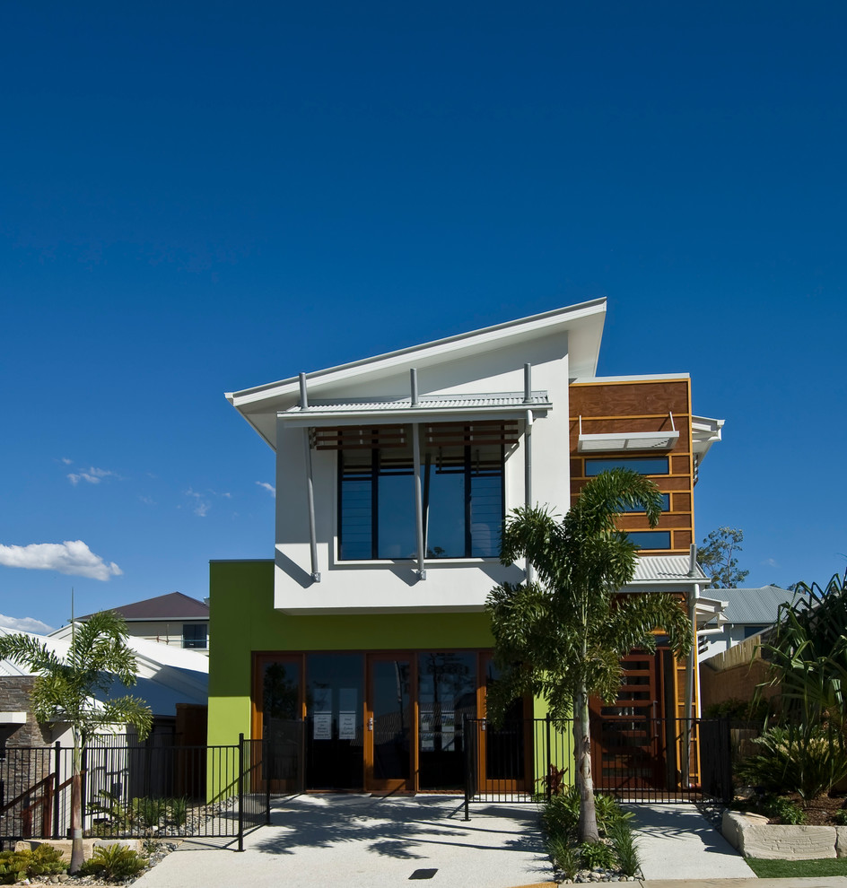 Inspiration for a mid-sized modern two-storey green exterior in Brisbane with wood siding and a flat roof.