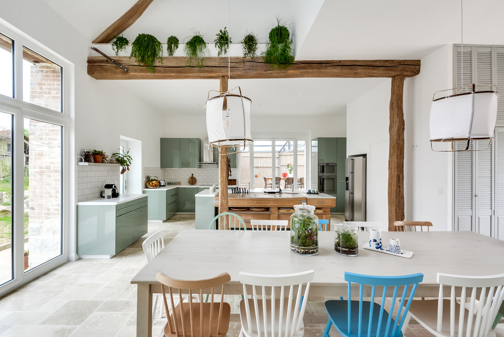 Photo of a large eclectic l-shaped open plan kitchen in Paris with an undermount sink, flat-panel cabinets, green cabinets, laminate benchtops, white splashback, subway tile splashback, panelled appliances, marble floors, with island and beige floor.