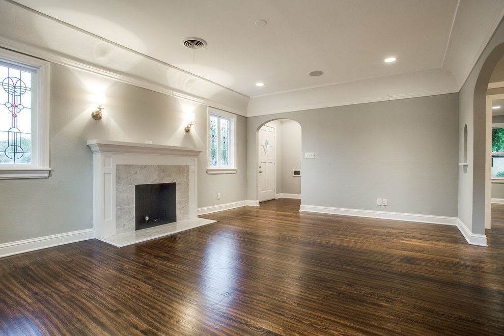 This is an example of a mid-sized traditional formal enclosed living room in Dallas with grey walls, medium hardwood floors, a standard fireplace, a tile fireplace surround and a wall-mounted tv.