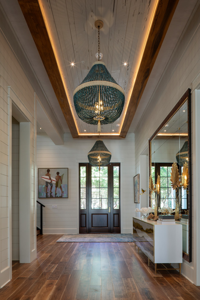 Large beach style foyer in Other with white walls, medium hardwood floors, a single front door, a dark wood front door, brown floor, wood and planked wall panelling.