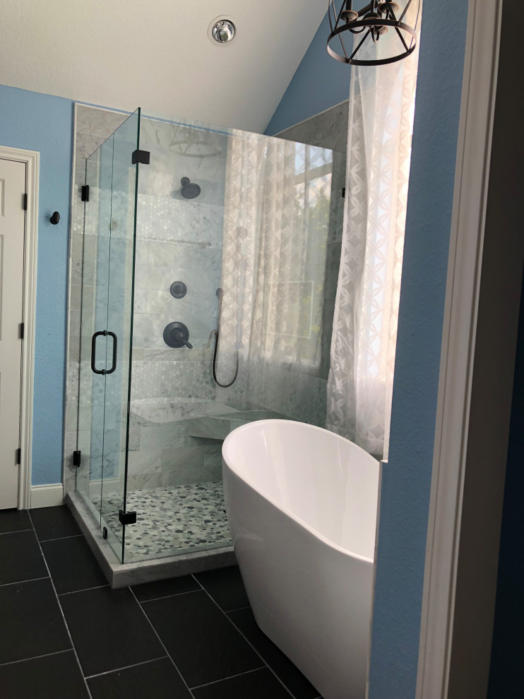 Exemple d'une salle de bain principale tendance de taille moyenne avec un placard à porte shaker, une baignoire indépendante, une douche d'angle, WC séparés, un carrelage gris, du carrelage en marbre, un mur bleu, un sol en carrelage de céramique, un lavabo encastré, un sol noir, une cabine de douche à porte battante, un banc de douche, meuble double vasque, meuble-lavabo encastré et un plafond voûté.