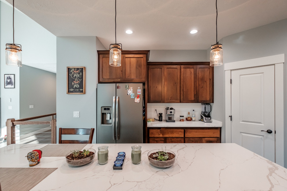 Arts and crafts kitchen in Portland with medium wood cabinets, granite benchtops, white splashback, subway tile splashback, stainless steel appliances, with island, brown floor, white benchtop and shaker cabinets.