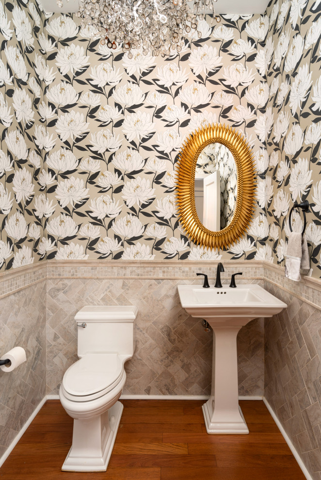 Inspiration for a medium sized modern cloakroom in Philadelphia with a one-piece toilet, beige tiles, stone tiles, medium hardwood flooring, a pedestal sink and wallpapered walls.