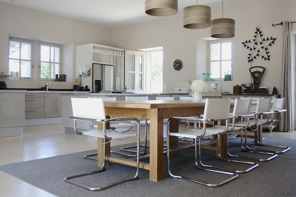 Large contemporary kitchen/dining combo in Amsterdam with white walls, concrete floors and no fireplace.
