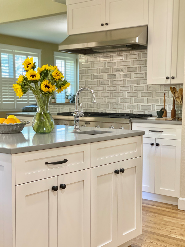 Inspiration for a large traditional l-shaped kitchen pantry in Denver with an undermount sink, shaker cabinets, white cabinets, quartz benchtops, panelled appliances, medium hardwood floors, with island and white benchtop.