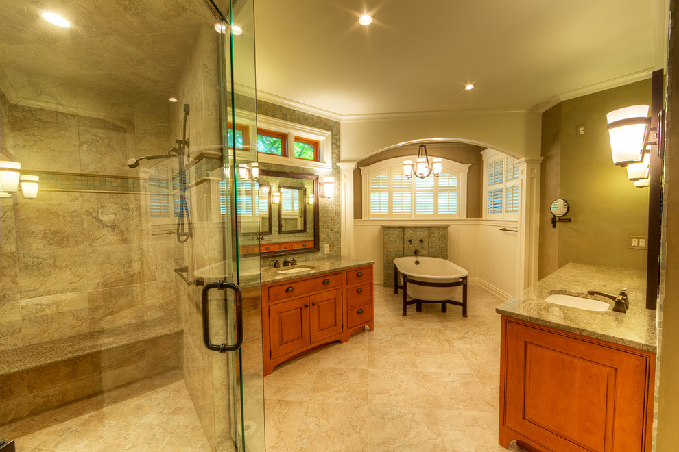 Mid-sized arts and crafts master bathroom in New York with raised-panel cabinets, light wood cabinets, granite benchtops, a freestanding tub, a corner shower, beige tile, stone tile, beige walls, ceramic floors, an undermount sink and beige floor.