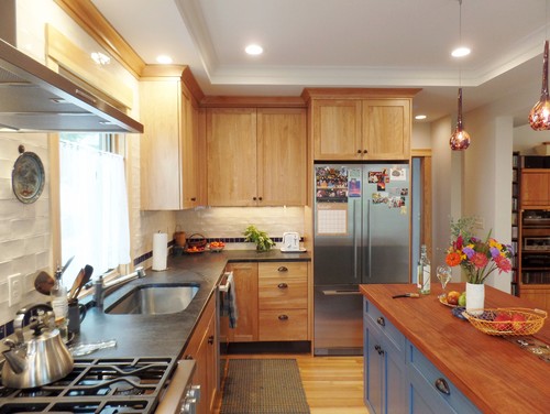 Eco-friendly kitchen with reclaimed wood kitchen cabinets, blue island and stainless steel appliances