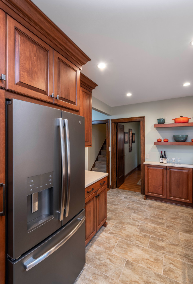 Photo of a small traditional galley separate kitchen in Indianapolis with an undermount sink, raised-panel cabinets, medium wood cabinets, quartz benchtops, multi-coloured splashback, glass tile splashback, coloured appliances, ceramic floors, no island, brown floor and white benchtop.