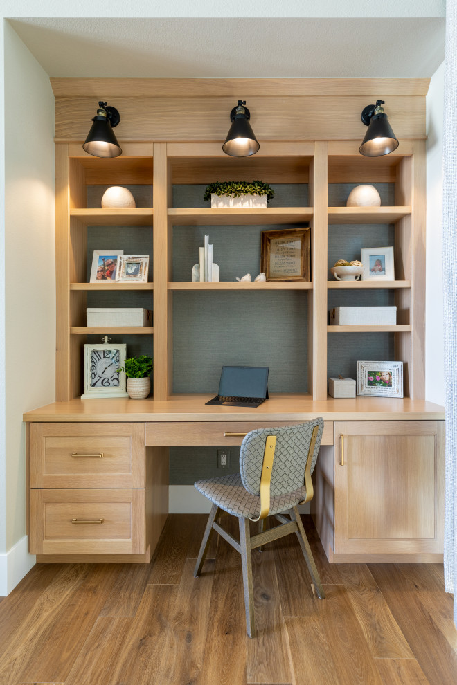 This is an example of a small transitional study room in Denver with white walls, medium hardwood floors, a built-in desk, brown floor and wallpaper.