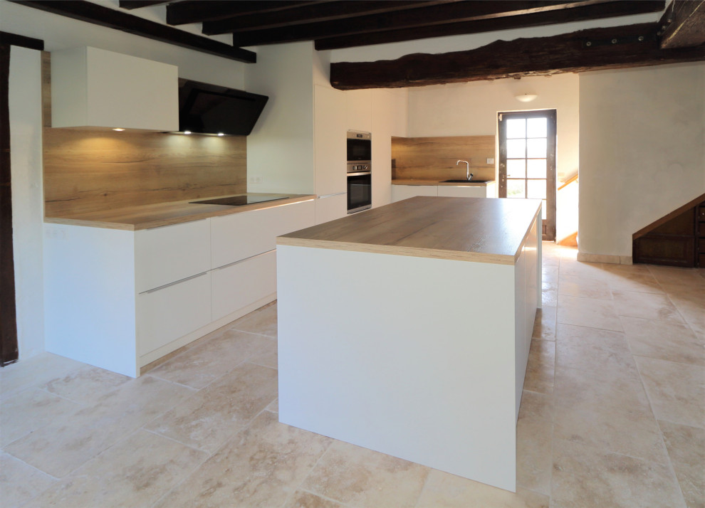 Photo of a large contemporary l-shaped open plan kitchen in Other with an integrated sink, flat-panel cabinets, white cabinets, wood benchtops, brown splashback, timber splashback, panelled appliances, ceramic floors, with island, beige floor, brown benchtop and exposed beam.