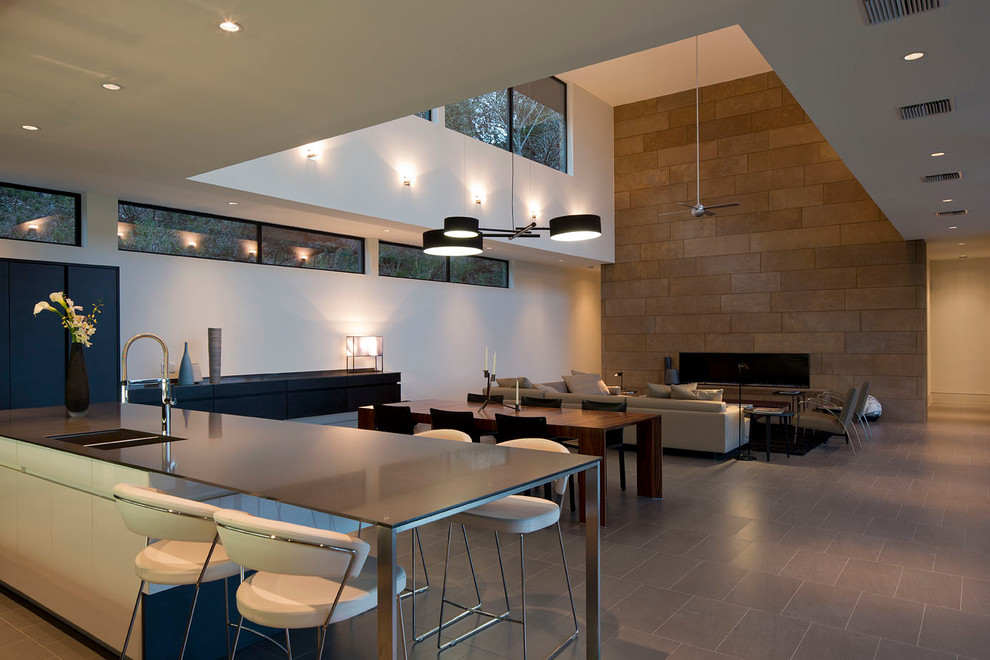 This is an example of a contemporary open plan kitchen in Austin with flat-panel cabinets.