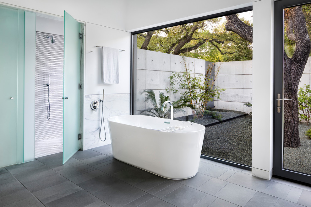 This is an example of a large midcentury master bathroom in Austin with a freestanding tub, a curbless shower, white tile, mosaic tile, white walls, porcelain floors, grey floor and a hinged shower door.