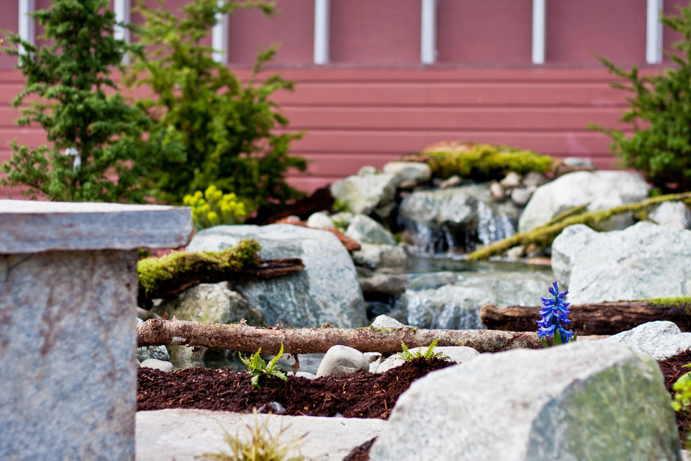 Inspiration for a mid-sized rustic partial sun backyard stone formal garden in Seattle for spring.