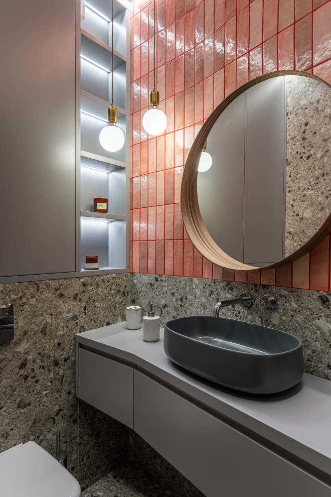 Пример оригинального дизайна: ванная комната среднего размера: освещение в современном стиле с серыми фасадами, полновстраиваемой ванной, биде, оранжевой плиткой, керамической плиткой, серыми стенами, полом из керамической плитки, накладной раковиной, столешницей из гранита, серым полом, серой столешницей, тумбой под две раковины, подвесной тумбой и плоскими фасадами