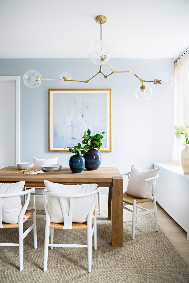 Inspiration for a beach style dining room in New York with blue walls, light hardwood floors and beige floor.