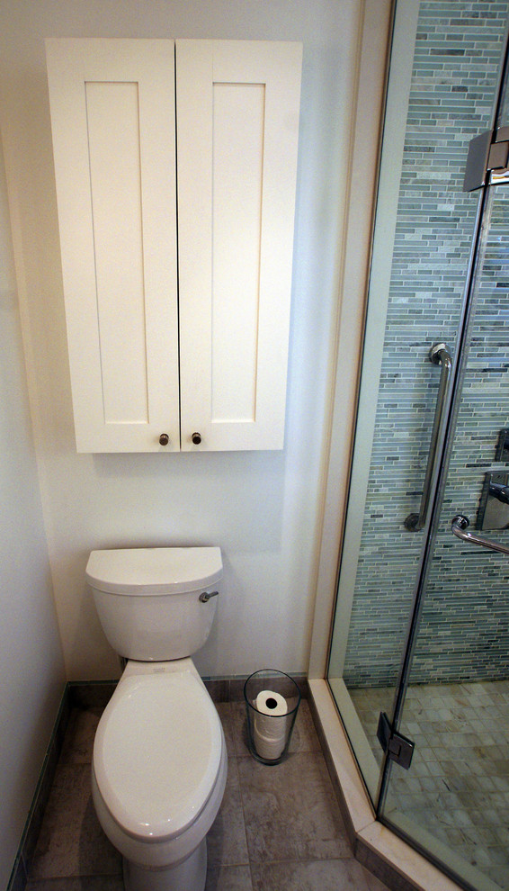 This is an example of a mid-sized eclectic master bathroom in Toronto with a pedestal sink, flat-panel cabinets, white cabinets, a freestanding tub, a corner shower, a two-piece toilet, multi-coloured tile, mosaic tile, white walls and light hardwood floors.