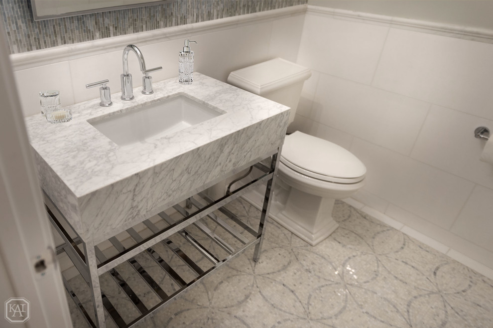 This is an example of a small transitional powder room in Chicago with open cabinets, a two-piece toilet, multi-coloured tile, mosaic tile, grey walls, marble floors, a pedestal sink, marble benchtops, multi-coloured floor and white benchtops.